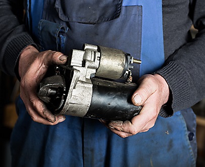 Mechanic holding a faulty Toyota forklift starter in his hand